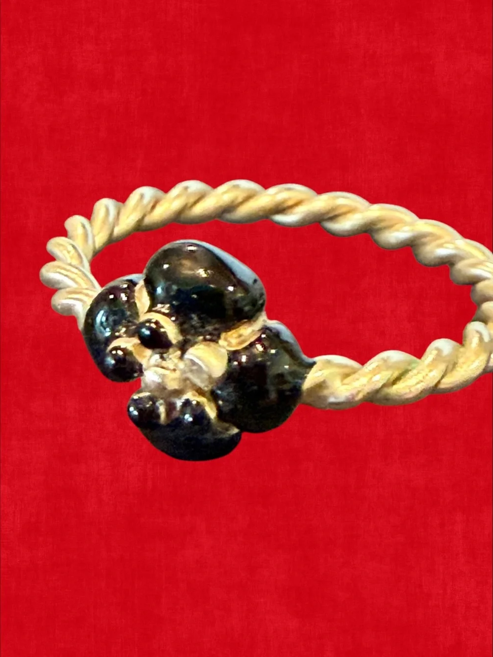 CHANEL Gold-Tone Twisted Band Ring with Black Floral Motif